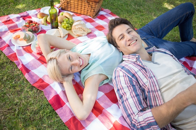Happy couple lying together at the park 