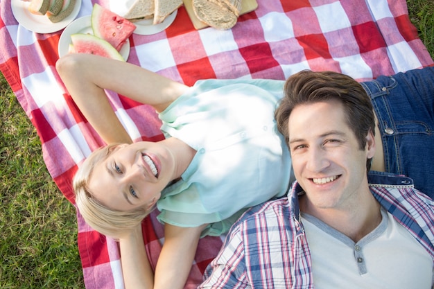 Happy couple lying together at the park 