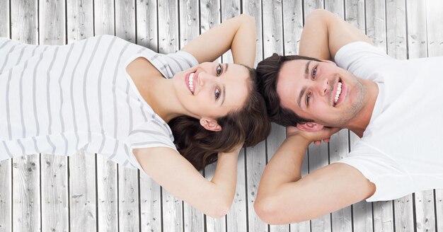 Happy couple lying on wooden background