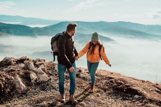 Felice coppia uomo e donna turista in cima alla montagna durante un'escursione in estate