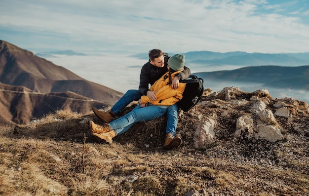 Happy couple man and woman tourist at top of mountain during a hike in summer