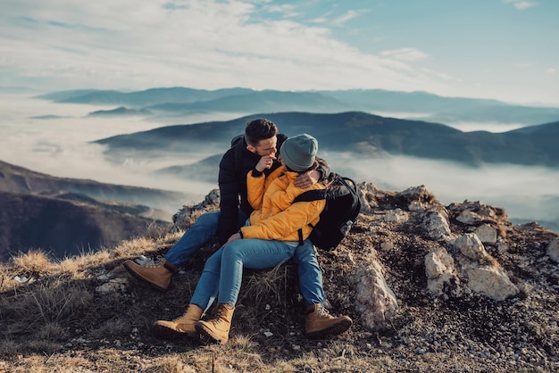 Happy couple man and woman tourist at top of mountain during a hike in summer