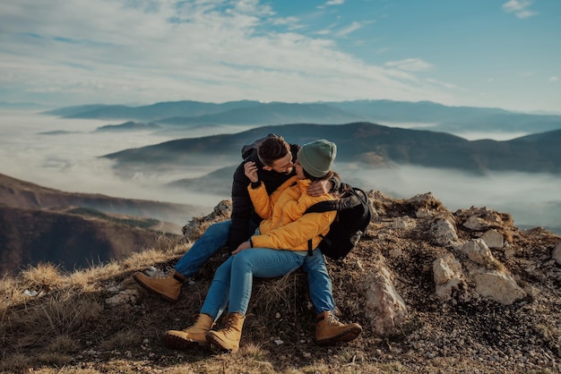 Happy couple man and woman tourist at top of mountain during a hike in summer