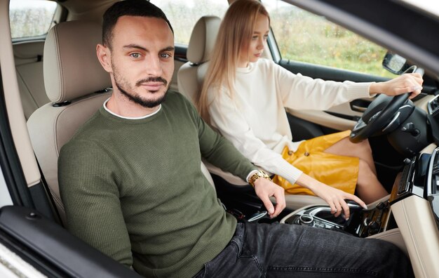 Happy couple man and woman traveling in car