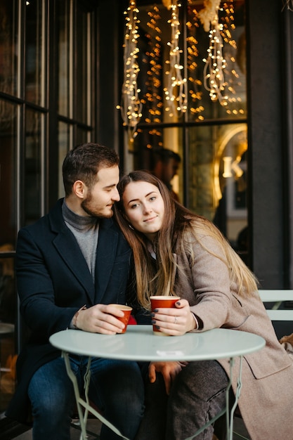 Coppia felice in un caffè all'aperto il giorno d'autunno