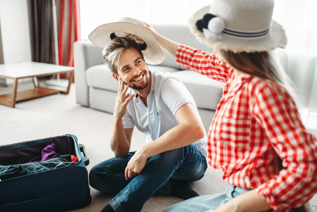 Happy couple packing their bags for vacation