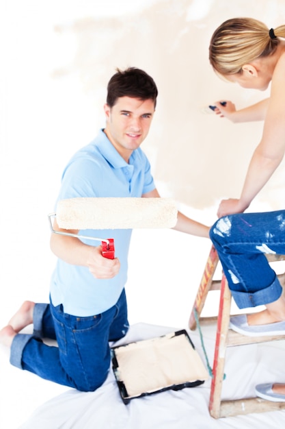 Happy couple painting a room