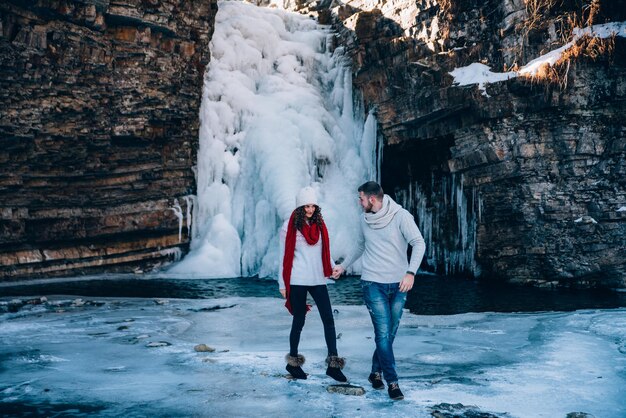 Happy couple playful together during winter holidays vacation outside in snow park