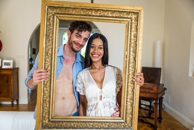 Happy couple portrait holding a frame