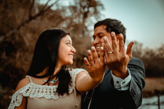 Happy couple posing in the field just married wedding couple wedding ring