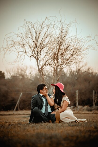 Happy couple posing in the field just married wedding couple