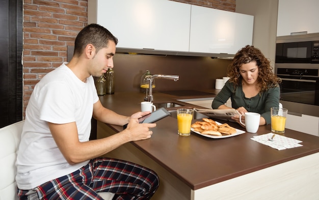 家の朝食でニュースを読んで幸せなカップル