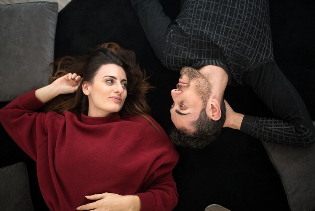 Happy couple relaxing on a carpet at home