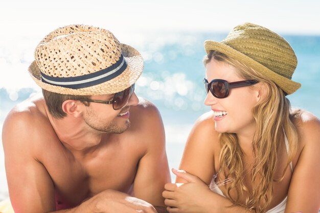 Happy couple relaxing together in the sand