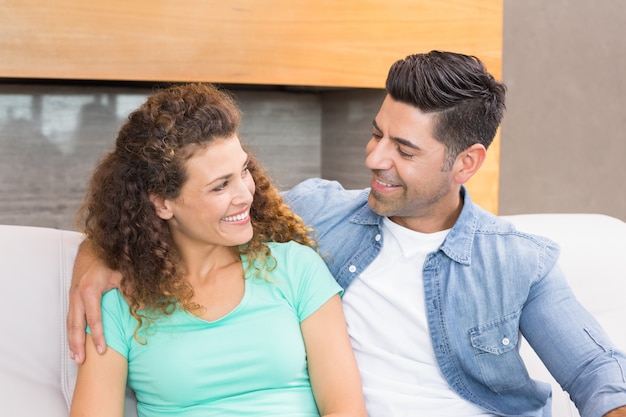 Happy couple relaxing together smiling at each other