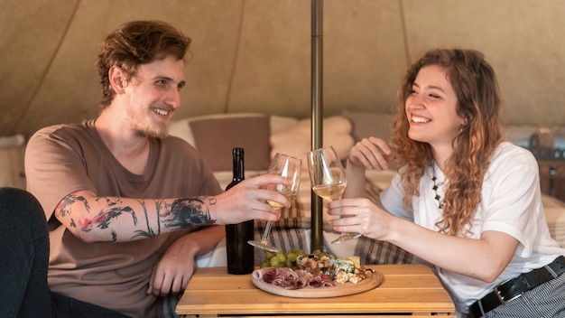 A happy couple resting in a tent at glamping Wine and food