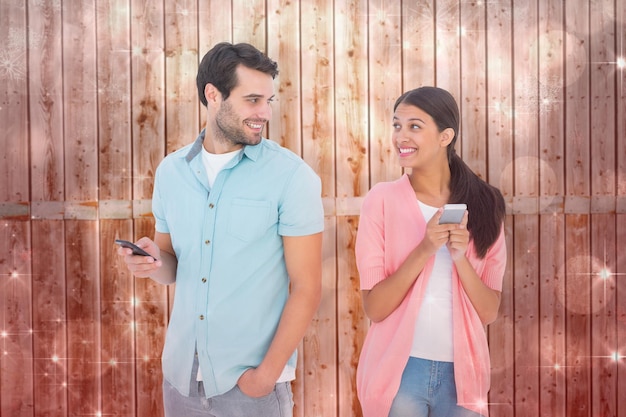 Счастливая пара отправляет текстовые сообщения на фоне мерцающего светлого дизайна на красном