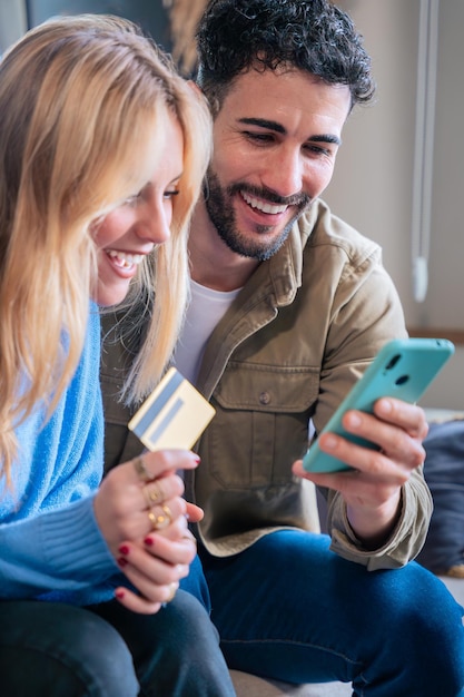 happy couple shopping online with credit card and smartphone smiling at screen