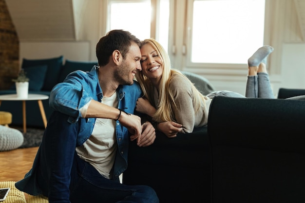 Happy couple showing affection while relaxing together in the living room