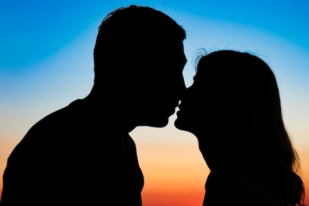 Happy couple silhouette against a sunset romance