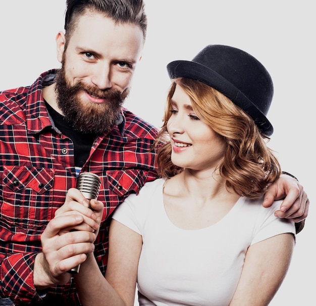 Happy couple singing in karaoke over white background