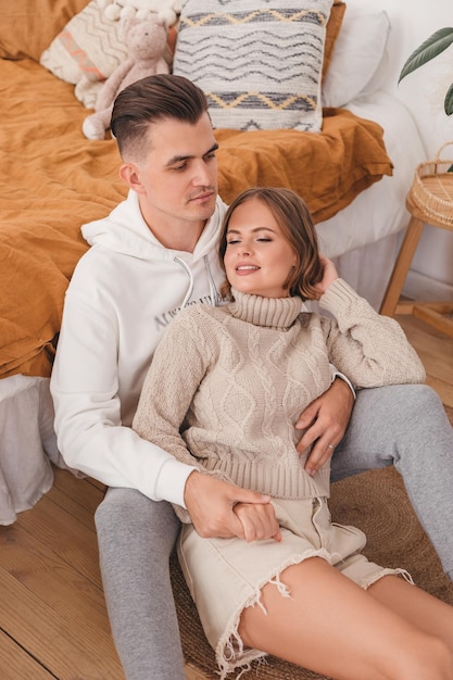 happy couple sit on the floor in the bedroom