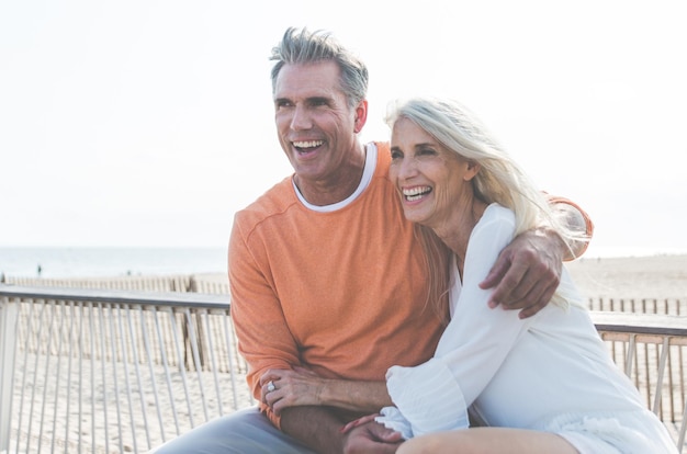 Photo happy couple sitting at beach