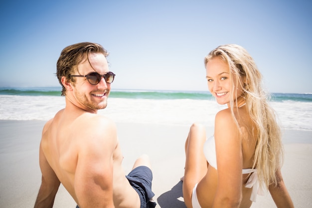 Happy couple sitting on the beach