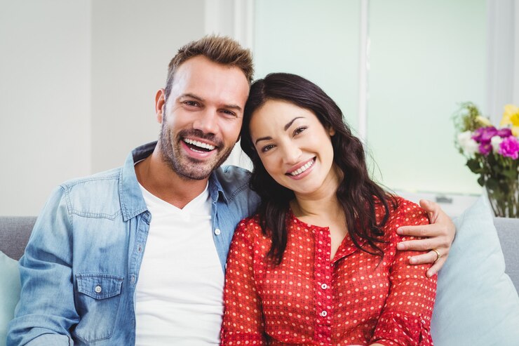 Photo happy couple sitting on sofa at home