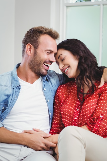 Happy couple sitting on sofa at home