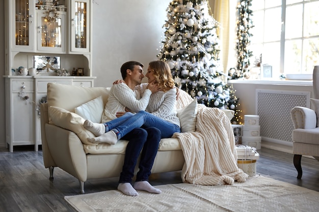 happy couple sitting on sofa at home