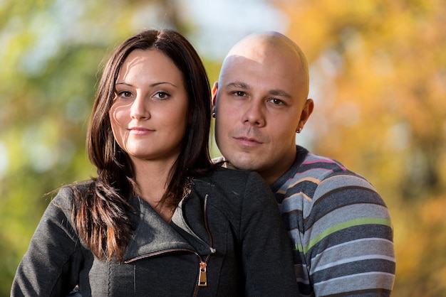 Photo happy couple sitting together in the woods during autumn