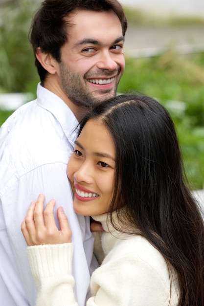 Happy couple smiling and hugging outdoors 