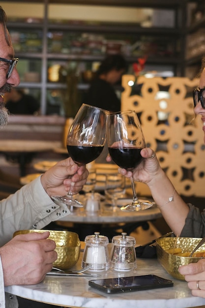 Happy couple smiling and talking in a restaurant drinking red wine Married couple having lunch break at cafe bar Lifestyle concept with man and a woman going out on weekend day