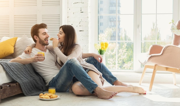 Happy couple spending morning together in bedroom. Casual man and woman in love, copy space