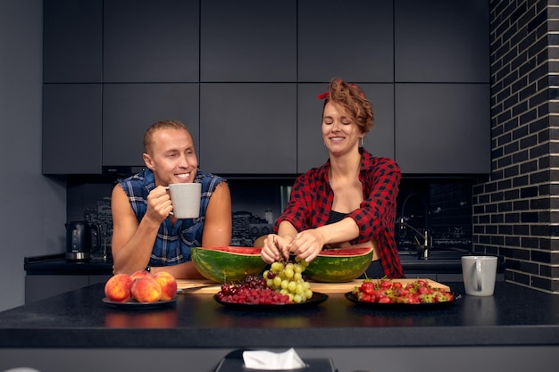 Happy couple standing in kitchen at home preparing together yummy dinner on first dating spouses chatting enjoy warm conversation and cooking process caring for health eating fresh vegetable salad