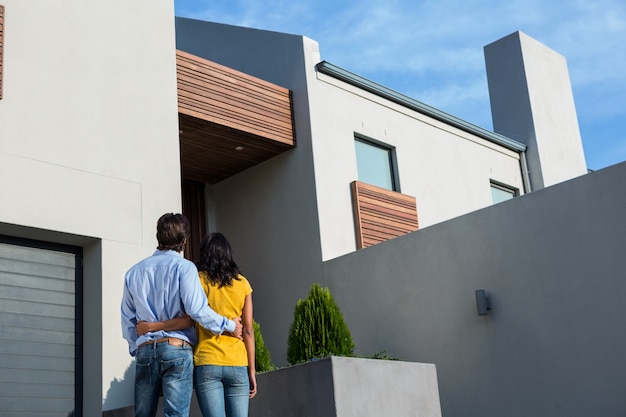 Coppie felici che stanno e che esaminano la nuova casa