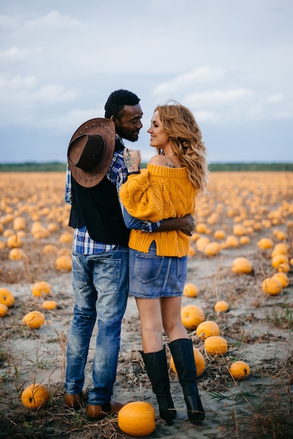 Happy couple standing in pumpkin field