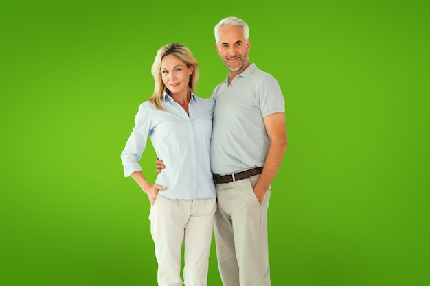 Happy couple standing and smiling at camera against green vignette