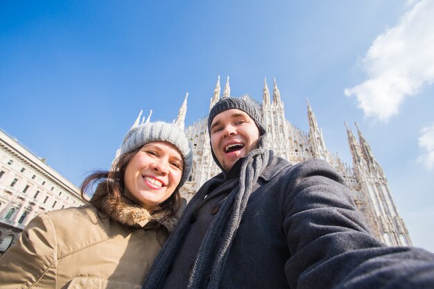 Happy couple taking self portrait in milano in duomo square