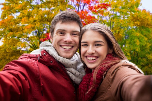 Photo happy couple taking selfie in autumn