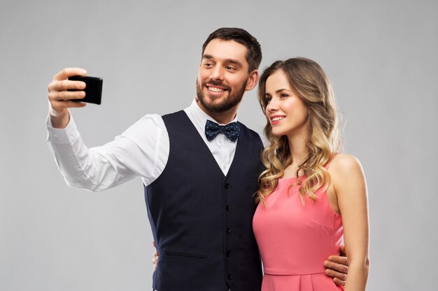 happy couple taking selfie by smartphone