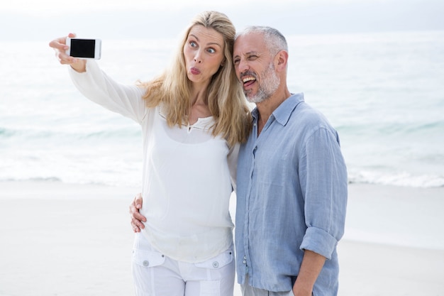 Coppie felici che prendono selfie con il telefono cellulare