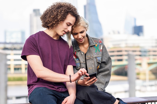 Photo happy couple talking sitting near river thames.