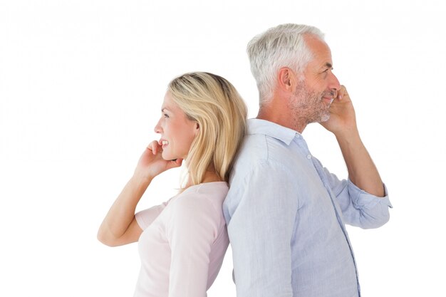 Happy couple talking on their smartphones