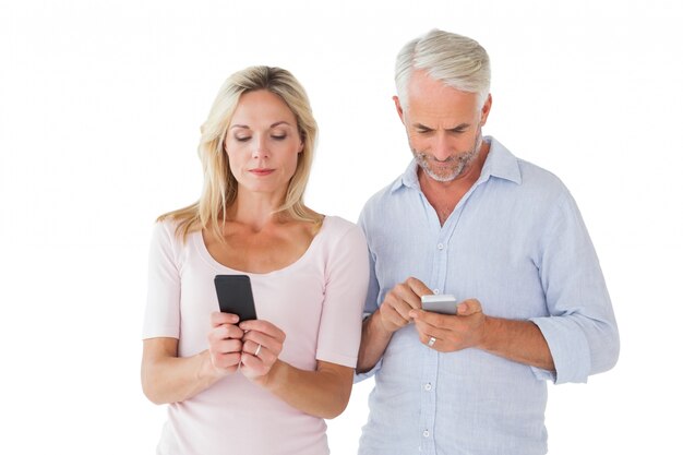 Happy couple texting on their smartphones