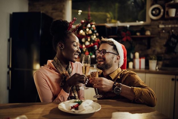 Happy couple toasting with Champagne at dining table on New Year's eve