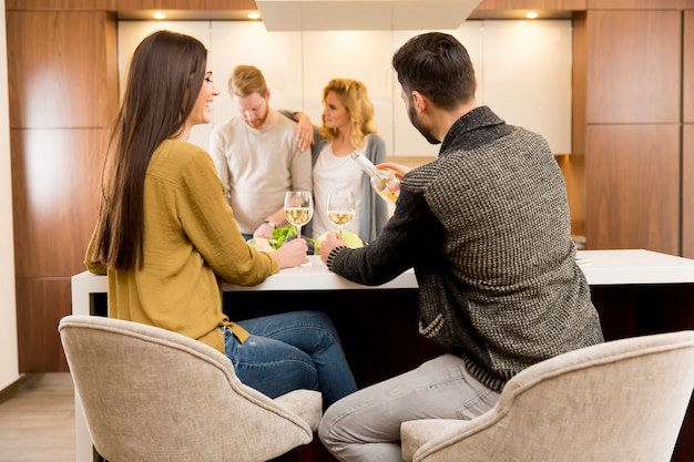 Happy couple toasting with white wine in the modern kitchen