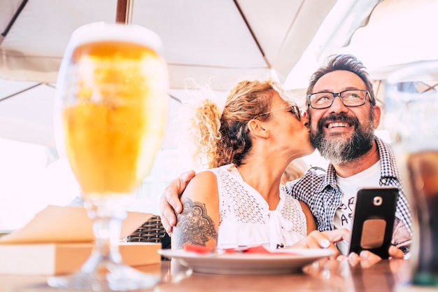 Photo happy couple together do a phone conference call sitting at the bar restaurant in outdoor