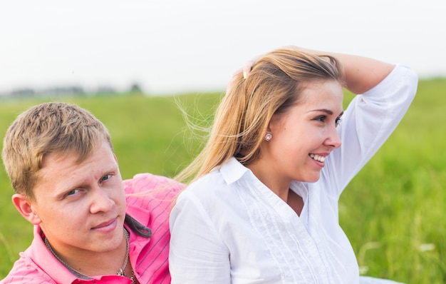 Happy Couple Together Relaxing on Green Grass. Park. Young Couple In Love Outdoor.